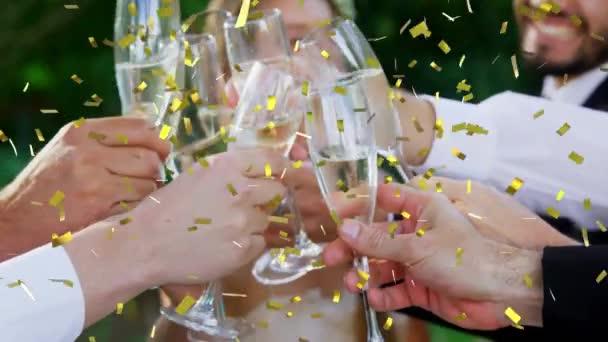 庭のパーティーで黄金のコンフェッティが落ちるシャンパンのグラスで乾杯する人々のグループのアニメーション — ストック動画