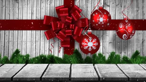 雪片が落下し 赤いリボンと赤ちゃんと冬の風景のアニメーション灰色の背景にクリスマスの装飾や木の板 — ストック動画