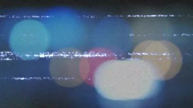 Koyu gri arkaplan üzerinde renkli Bokeh ışıkları çemberleri üzerinde parazit bantları olan bir ekranın canlandırması