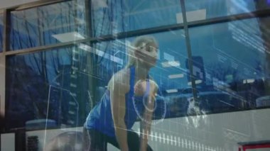 Veri işleme, tarama ve analiz animasyonu. Arka planda kettlebell olan sarışın, beyaz bir kadınla spor salonunda çalışıyor.