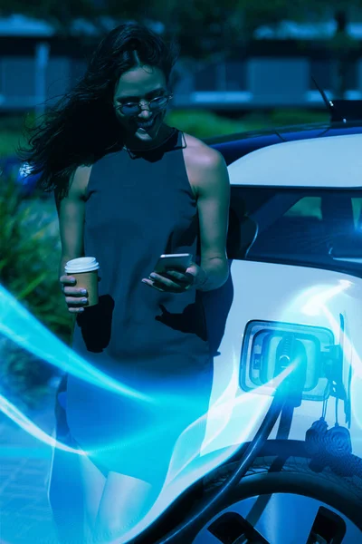 Blue Wave Woman Using Mobile Phone While Charging Electric Car — Stock Photo, Image