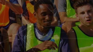 Koltuklarda oturan, su içen ve arka planda dinlenen bir spor takımının ön görüntüsüyle bağlantılı bir ağ animasyonu