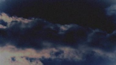 Parazit mavi ve kırmızı bantlı bir ekranın animasyonu ve arka planda mavi bir gökyüzünde hızla hareket eden beyaz bulutların görüntüsü