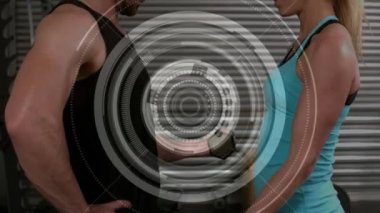 Kafkasyalı bir erkek ve kadının arka planda dambıllarla çalışmasının animasyonu.