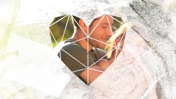 一对快乐的白种人夫妇在阳光下拥抱在一起 在阳光下微笑 身后有树木 他们的动画 透过一个白色的心形窗向前方看去 — 图库视频影像