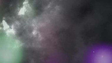Animation of out of focus multi colored spotlights moving around in hypnotic motion with thunderstorm and moving clouds of smoke in the background. Seamless loop of digital motion.