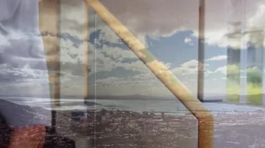 Şehir manzarası konusunda hemfikir olan iş adamlarının el sıkışması ve arka planda mavi gökyüzü bulutları..