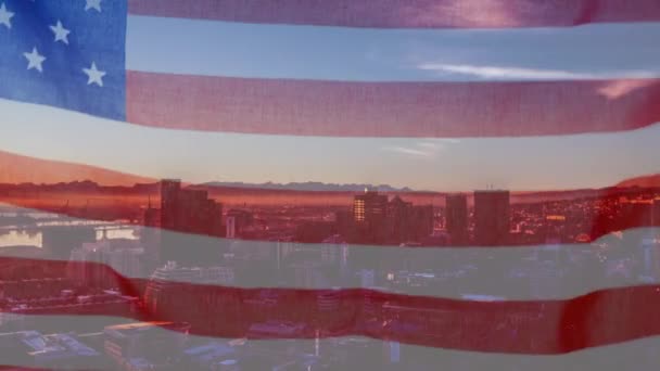 在一个阳光明媚的日子里 在一个现代化的城市景观面前挥动着美国国旗的动画 背景是蓝天上的云彩 爱国主义与现代城市形象组合概念 — 图库视频影像