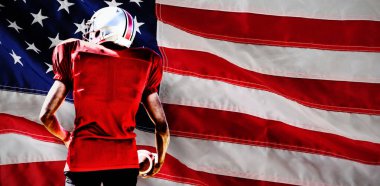 Amerikan Futbolcusu bir Amerikan bayrağına karşı