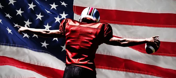 美国足球运动员对着一面美国国旗的特写 — 图库照片