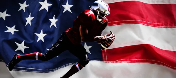 美国足球运动员与美国国旗相对照 — 图库照片