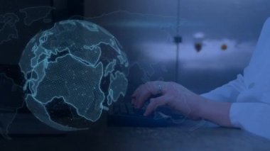 Dijital mavi dünyanın dönmesi ve arka planda bilgisayar klavyesinde yazı yazan birinin elleri animasyonu.