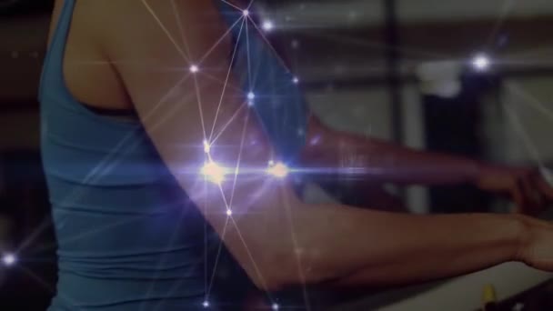 Animation d'un réseau de connexions, traitement de données et enregistrement de statistiques avec des athlètes féminines courant sur des tapis roulants dans un gymnase au ralenti en arrière-plan .