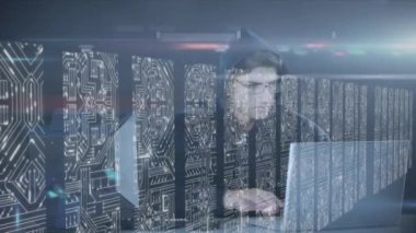 İki dizüstü bilgisayar, veri işleme ve dijital bilginin sunucu ağındaki beyaz ışık izlerinin yüzey üzerinde aktığı bir sunucu odasında çalışmasının animasyonu. 