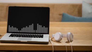 Kulaklıklı dizüstü bilgisayarın ekranında görüntülenen grafik eşitleyicisinin en yüksek seviye hareketli göstergesi. Küresel iletişim modern teknoloji konsepti dijital olarak oluşturulmuş görüntü.