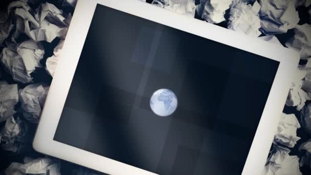 背景にある複数の紙玉にデジタルタブレットの画面に表示される回転する地球のアニメーション — ストック動画