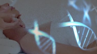 Bir güzellik tedavisi sırasında arka planda gözleri kapalı bir şekilde bir klinikte uzanan bir kadınla dönen mavi renkli DNA iplikçiklerinin canlandırması.. 