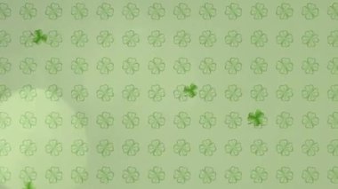 Aziz Patrick Günü şablonunun animasyonu. Yeşil yoncalar dönüyor, yeşil yoncalar düşüyor. Işıklar hareket ediyor ve açık yeşil arka planda yanıp sönüyor..