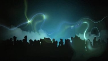Yeşil ve mavi duman izleri hipnoz hareketinde kusursuz bir döngü içinde hareket ediyor ve yeşil arka plandaki bir müzik konserinde kollarını havaya kaldırmış insanların siluetlerini gösteriyor.. 