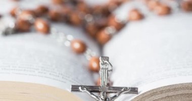 Arka planda Kutsal Kitap 'ın üzerinde gümüş haç bulunan Hıristiyan tespihi animasyonu. Paskalya dini kavramı dijital olarak oluşturuldu. 4k