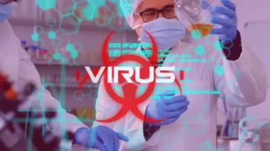 Virüs kelimesinin beyaz olarak yazılması, DNA iplikçiklerinin dönmesi ve sağlık tehlike işareti üzerinde veri işlemesi. Laboratuvarda çalışan bilim adamları koruyucu giysiler, yüz maskesi, gözlükler ve arka planda cerrahi eldivenler giyiyorlar.. 