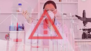 Veri işleme animasyonu, kırmızı üçgen uyarı işareti, Coronavirus Covid-19 'un yüz maskesi takan kadın bilim adamına yayılması, arka plandaki laboratuvarda çalışan koruyucu ameliyat eldivenleri ve gözlükler..