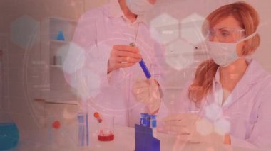 Kimyasal bileşiklerin hareketli yapısal formüllerinin canlandırılması ve Coronavirus Covid-19 'un arka plandaki laboratuvarda koruyucu yüz maskeleri ve cerrahi eldivenlerle çalışan kadın bilim adamlarına yayılması.. 