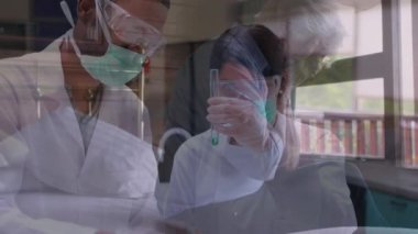 Üst düzey bir kadının hastane yatağında oturup, laboratuarda çalışan erkek ve kadın bilim adamlarının üzerinde yüzlerini saklaması ve arka planda koruyucu gözlük ve cerrahi eldiven takması animasyonu..