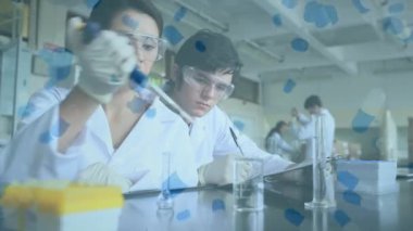 Koronavirüs animasyonu erkek ve kadın bilim adamlarına yayılıyor. Laboratuvarda çalışan doktorlar koruyucu gözlük takıyor ve arka planda cerrahi eldiven takıyor.. 