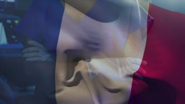 Fransız bayrağının koruyucu giysiler ve yüz maskesi giymiş bir kadın doktorun ameliyat odasında dikilip arka plandaki kameraya baktığı animasyon.. 