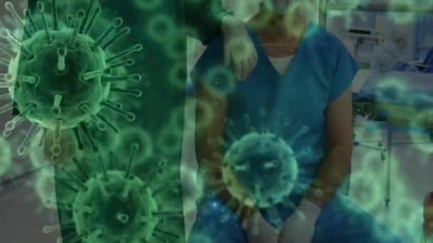 Animation du macrocoronavirus Covid-19 cellules se propageant sur les médecins masculins et féminins portant des vêtements de protection et masque facial debout dans une salle d'opération, en regardant la caméra en arrière-plan . 