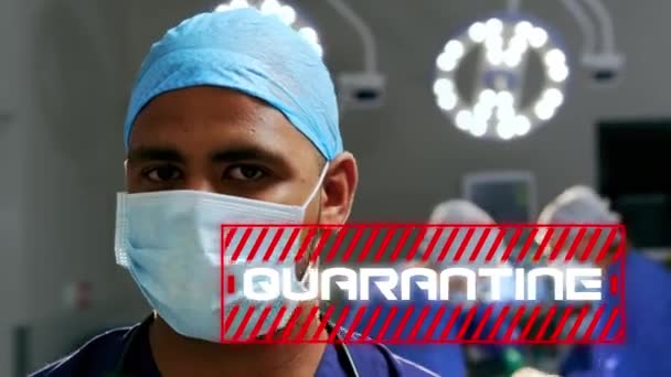 手術室に立つ男性医師の上に赤い枠に白い文字で書かれた隔離という言葉のアニメーション 背景にカメラを見て — ストック動画