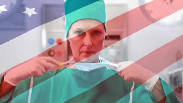 美国国旗在女医生面前飘扬的动画 背景是戴口罩 — 图库视频影像