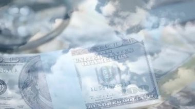 Parçalanmış Amerikan dolar sembolü, steteskop, Amerikan doları banknotları, Coronavirus Covid-19 'un animasyonu. Arka planda mavi gökyüzünde yayılan bulutlar.. 