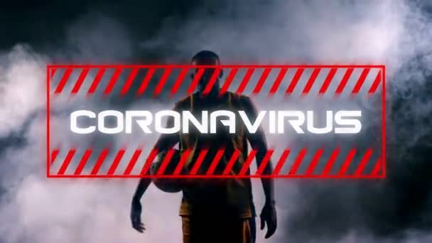 背景にボールを持つ男性バスケットボール選手の上に赤い枠に白い文字で書かれた単語コロナウイルスのアニメーション — ストック動画