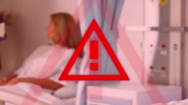Kırmızı üçgen uyarı işareti, Coronavirus Covid-19 arka plandaki bir hastane odasında hastalarla ilgilenen doktorlara yayılıyor.. 