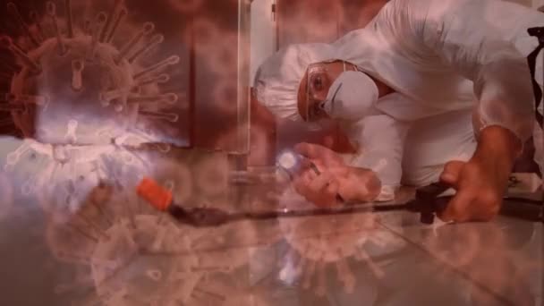 マクロコロナウイルスのアニメーション保護服や保護用のゴーグル 保護手袋 フェイスマスクを身に着けている男の上に広がっているCovid 19細胞は 消毒スプレーを保持し 背景に噴霧 — ストック動画