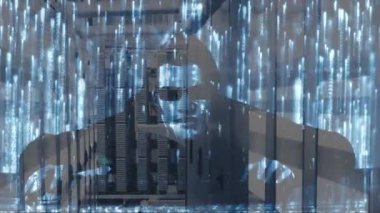 Kapüşonlu bir adamın gözlük takarak bilgisayarı hacklemesi, veri işleme ve dijital bilgilerin sunucu odasındaki bilgisayar sunucularından geçerek yüzeyde ışık yollarının parlaması animasyonu. 