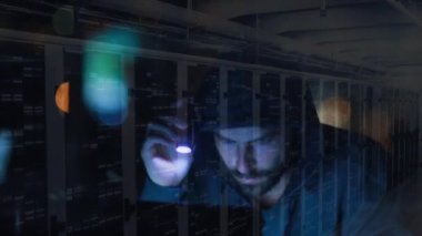 Elektrik feneri, veri işleme ve dijital bilgi kullanarak bilgisayar hackleyen kapüşonlu bir adamın animasyonu bir sunucu odasındaki bilgisayar ağı üzerinden yüzey üzerinde ışık izleri yanıp sönüyor..