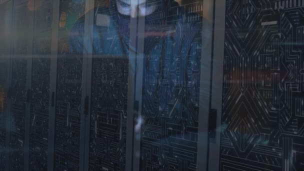 一个身穿巴拉克拉瓦 数据处理和数字信息的黑客攻击计算机的人在服务器机房网络中穿行 表面闪烁着光迹的动画 — 图库视频影像