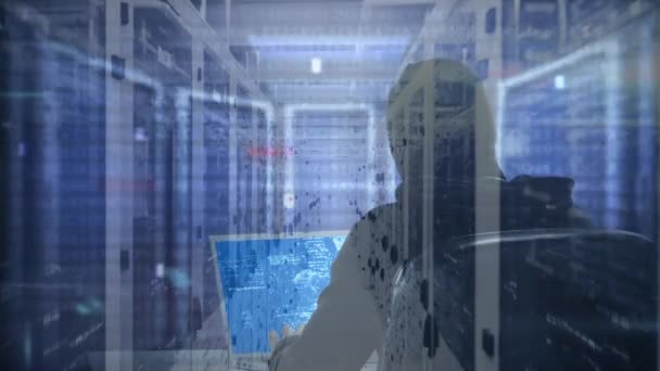 バラクラバを身に着けているコンピュータをハッキングする男のリアビューのアニメーション 表面に光の道が点滅しているサーバールーム内のコンピュータサーバーのネットワークを流れるデータ処理とデジタル情報 — ストック動画