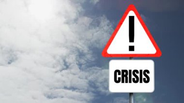 Kriz sözcüğünün animasyonu beyaz tabela üzerinde siyah harflerle ve üçgen yol işaretinde uyarı işareti ile yazıldı, arka planda tekrarlanan hareketlerle gökyüzü üzerinde kusursuz döngü içinde hareket eden beyaz bulutlar. 