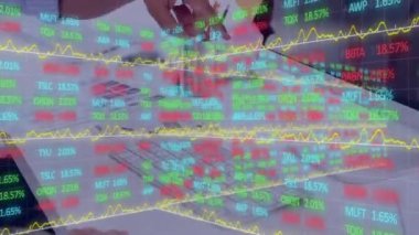 Hisse senedi piyasasının rakamlar ve grafiklerle canlandırılması, borsada fiyatların yükselmesi ve düşmesi, arka planda bilgisayar kullanarak çalışan insanlarla veri kaydının yapılması.