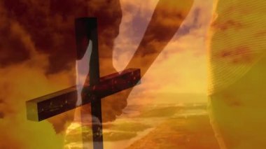 Hıristiyan siluetinin animasyonu arka planda hızla hareket eden turuncu bulutlar ve el ele tutuşan çiftlerin orta bölümünden geçiyor. Paskalya dini kavramı dijital olarak oluşturulmuş görüntü.