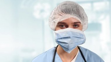 Korumacı yüz maskesi takan kadın doktor, kamera koronavirüsüne bakıyor.. 