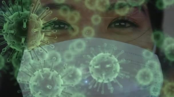 Animation de cellules de macro coronavirus Covid-19 étalées sur un portrait rapproché d'une femme métisse portant un masque facial regardant droit devant la caméra . 