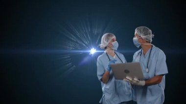 Yüz maskesi takan iki doktorun, arka planda parlak noktalardan oluşan bir küre üzerinde dizüstü bilgisayar kullanmasının animasyonu. Halk sağlığı salgını Coronavirus Covid 19 salgın konsepti dijital bileşik.