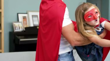 Kelimelerin animasyonu # Beyaz harflerle beyaz harflerle yazıldı mutlu beyaz kız ve babası kırmızı süper kahraman şapkaları takıp evde birlikte oynadılar.. 