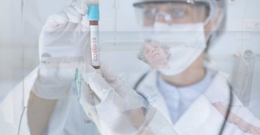 Koruyucu Google, eldiven ve yüz maskesi takan bir doktorun dijital çizimi. Elinde COVID 19 işareti olan bir test tüpü var. Arka planda, hastane yatağında yatan yaşlı bir kadın hasta üzerinde..