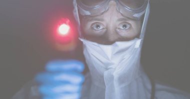 Yüz maskesi takan bir doktorun dijital çizimi. Arka plandaki mavi ve kırmızı ışıkların üzerindeki kameraya bakıyor..